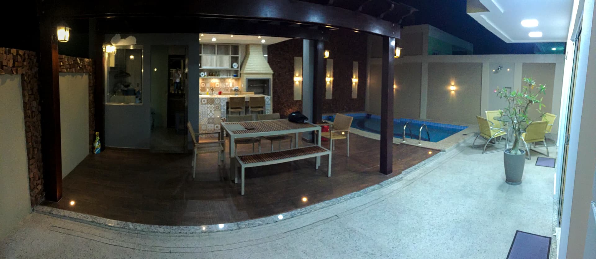 Vista ampla da área gourmet coberta com pergolado e piscina