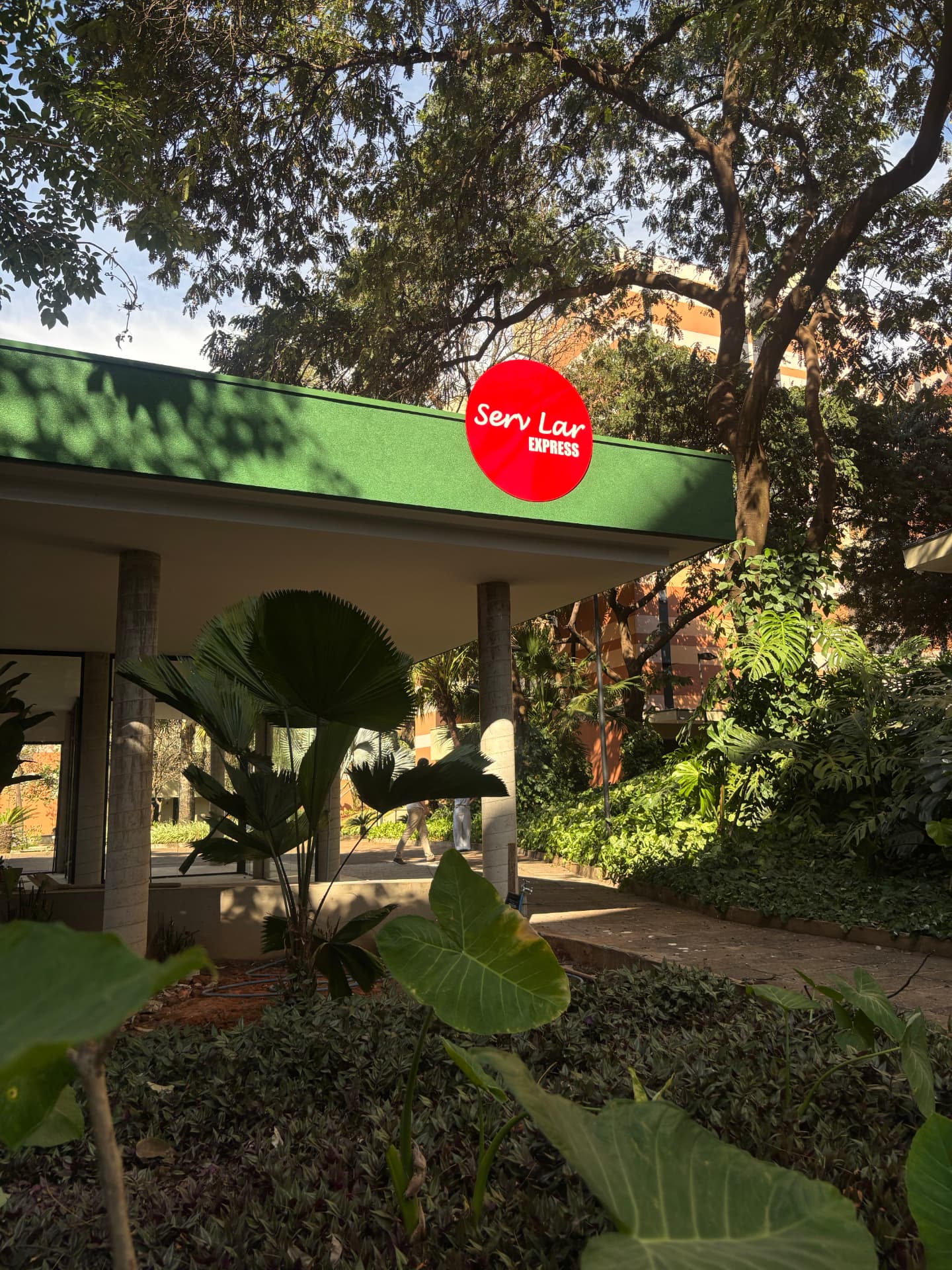 Fachada comercial reformada com paisagismo e comunicação visual